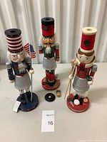 Front view of all three nutcrackers showing colors, details and damage on one figure