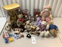 Full lot overview showing various teddy bears including boxed and loose bears with different accessories and clothing, mouse statue visible