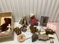 Overview of all items on display including teddy bears, dolls, accessories, and plush pie