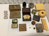 Overview of the trinket box collection showing various boxes of metal, wood, glass, and ceramic. Includes Whitmans Salmagundi style gold-tone metal box, wood boxes with playing card and giraffe motifs, yellow ceramic boxes and small glass boxes.
