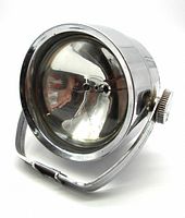 Angled view of vintage chrome searchlight showing glass lens, reflector, chrome casing, and mounting bracket
