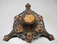 Top view of the antique Victorian cast iron Christmas tree stand showing the central wooden insert and intricate decorative cast iron design.