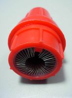 Close-up view of one end of the battery terminal post cleaner showing tightly packed metal wire bristles inside an orange plastic casing