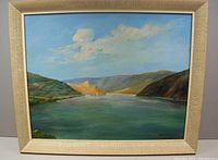 Full view of the framed original oil painting showing the Okanagan landscape with lake and hills under a blue sky with clouds.