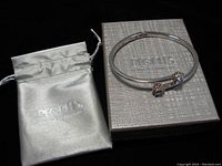 Bracelet beside matching silver drawstring gift pouch and gray textured box with People's Jewelers logo