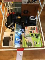 Full view of lot with Apple TV 4K box, Garmin GPS devices, Fitbit tracker, wallet, paper clips box, headphones, and Range Kleen cleaning kit.