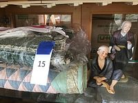 Japanese figurines and assorted blankets stacked in front of a cabinet
