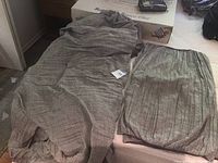 Grey striped king size duvet cover and matching pillowcases laid out on bed surface, showing fabric texture and pattern.