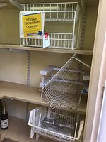 White metal wire 2-drawer kitchen/bath organizer on shelf with label visible.