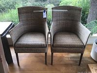 Two matching rattan armchairs placed side by side