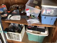 Wide view of shelf with Remington chainsaw, cords, multiple tubs with tools and accessories, and storage boxes