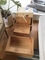 Stacked wooden boxes including three 'Luce' branded boxes and two unbranded light wooden boxes.