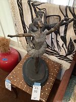 Front view of the bronze sculpture showing male dancer supporting female en pointe on oval base