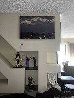 Photo showing statues arranged in wall niches including guardian angel, church figures, Native American horseman, and surrounding decor