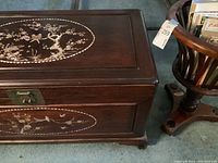 Side view of rectangular chest showing front abalone inlay and brass latch