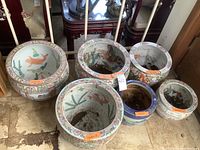 Six porcelain planter bowls arranged showing interiors and exteriors