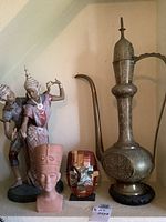 Group shot of all four decorative pieces: Balinese dancers, Nefertiti bust, mask, Indian ewer