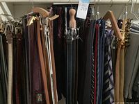 Assorted leather belts on wooden hanger