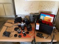 Overhead view of camera, six lenses, carry case, charger and cleaning papers laid out