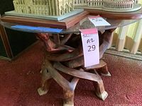 Full view of the wood base glass top table showing the sculpted human figure legs from one side.