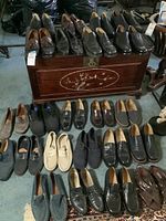 Top of wooden trunk with six pairs of leather shoes arranged side by side