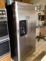 Front view showing stainless steel doors, integrated dispenser and handles