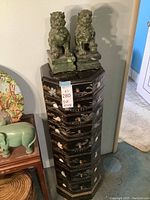 Overall view of the black lacquered jewelry armoire topped with two jade Foo dog statues