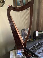Full view of wooden harp with carved Celtic knot work leaning on stand