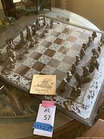 Full view of acrylic chess board with pewter figurines and instruction booklet