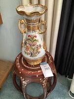 Casa Bohemia vase placed on wooden side table with abalone inlay, showing full item and label.