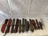 Wide view of all sheathed knives laid side by side