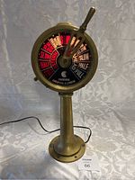 Full view of the vintage Chadburns engine order telegraph light with brass base and circular dial illuminated displaying engine commands.