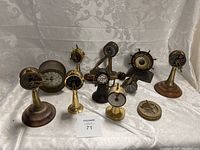 Front view showing the full collection of 10 small maritime-themed instruments including engine order telegraphs and a ship's clock.