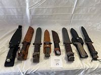 All eight knives and sheaths laid out on white background