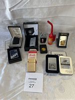 Full lot arranged on white fabric background showing all 9 lighters including boxed and unboxed items