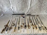 Full overview of all miniature swords, letter openers, and scabbards laid out on white backdrop