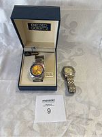 Both watches displayed: Seiko in box on left labeled Seiko Quartz, Casio watch on right