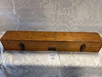 Closed wooden box with metal clasps, housing the naval spyglass.