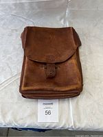 Closed vintage leather satchel viewed from the front showing worn brown leather and flap closure with strap