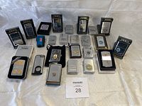 Overview of all 24 items including boxed and loose Zippo lighters, BIC lighter, cigar cutter, and coin set