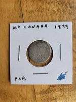 Front side of the 1899 Canadian 10 cent silver coin showing date and denomination in a cardboard holder.