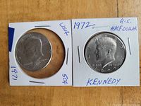 Obverse view of two Kennedy half dollar coins dated 1971 and 1972 in protective holders