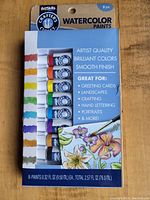Packaged set of 8 Crafters Closet watercolor paint tubes in original packaging on wooden surface