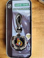 Front view of the clip-on watch attached to the packaging board showing Ottawa Senators logo and watch design.