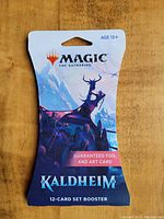 Photo of unopened Magic The Gathering Kaldheim 12-card set booster pack with guaranteed foil and art card.