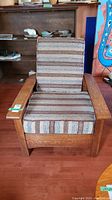 Front view of mission style oak chair with striped cushion upholstery.