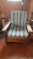 Front view of the mission style wooden chair with striped fabric cushions on seat and backrest.