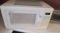 White Sunbeam microwave oven showing front with door and window