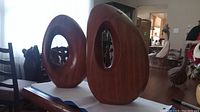 Two oval ring sculptures side by side on table showing overall scale