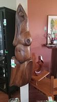 Full view of carved nude female wall sculpture in oak wood, mounted on wall.